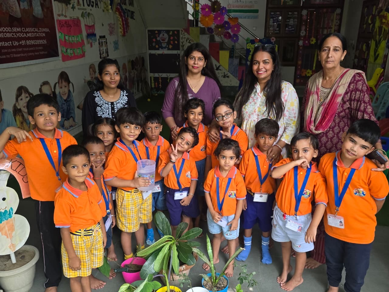 Children with their teachers and the plants they are growing